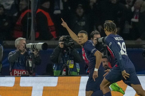 PSG's Kylian Mbappe, left, celebrates with PSG's Bradley Barcola after scoring his side's opening goal during the Champions League round of 16 first leg soccer match between Paris Saint-Germain and Real Sociedad, at the Parc des Princes stadium in Paris, France, Wednesday, Feb. 14, 2024. (AP Photo/Christophe Ena)