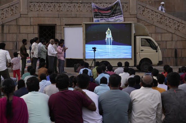 People watch the landing of Chandrayaan-3, or "moon craft" at Omani University in Hyderabad, India, Wednesday, Aug. 23, 2023. (AP Photo/Mahesh Kumar A.)