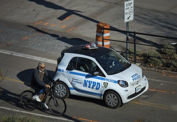 
              A police car blocks the bike path at the intersection of Houston and West streets as man drives his bike on Thursday, Nov. 2, 2017, in New York. A man in a rented pickup truck mowed down pedestrians and cyclists along the busy bike path near the World Trade Center memorial on Tuesday, killing at least eight and seriously injuring others in what the mayor called "a particularly cowardly act of terror." (AP Photo/Andres Kudacki)
            
