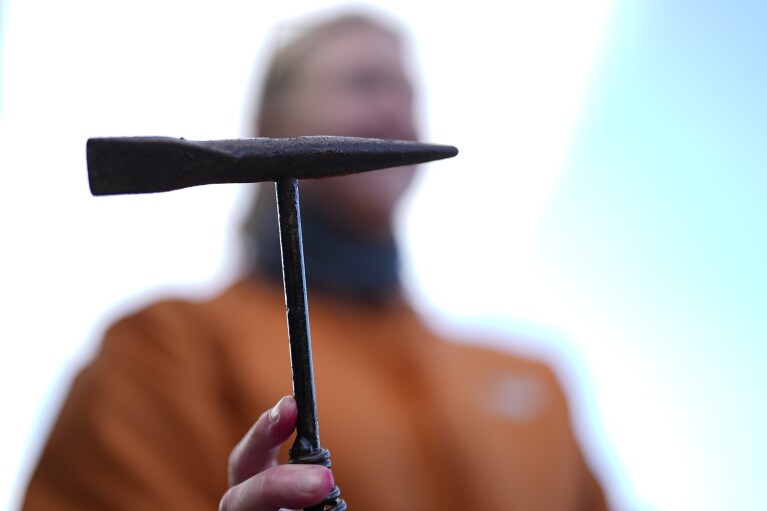 Joy Hollenback holds the hammer she uses to crush urchins, Saturday, Sept. 30, 2023, near Caspar, Calif. (AP Photo/Gregory Bull)