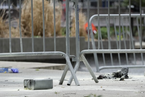 A metal can sits on the ground at the scene where a man lit himself on fire in a park outside Manhattan criminal court, Friday, April 19, 2024, in New York. Emergency crews rushed away a person on a stretcher after fire was extinguished outside the Manhattan courthouse where jury selection was taking place Friday in Donald Trump's hush money criminal case. (AP Photo/Mary Altaffer)