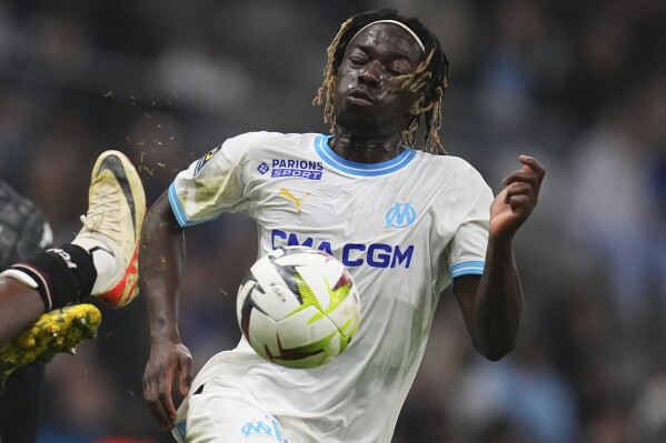 Marseille's Bamo Meite challenges for the ball during the French League One soccer match between Marseille and Metz at the Stade Velodrome in Marseille, France, Friday, Feb. 9, 2024. (AP Photo/Daniel Cole)