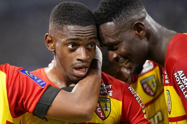 Lens' David Costa celebrates with teammate Salis Abdul Samed, right, after scoring the opening goal during the French League One soccer match between Marseille and Lens at the Velodrome stadium in Marseille, southern France, Saturday, Oct. 22, 2022. (AP Photo/Daniel Cole)