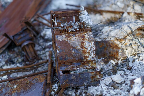 FILE - An old cash register sits among the charred remains of a home burned in the Slater Fire in Happy Camp, Calif., Oct. 6, 2021. The U.S. government has threatened to sue a unit of Warren Buffett’s Berkshire Hathaway to recover nearly $1 billion of costs related to the wildfires in 2020 in southern Oregon and northern California. The potential lawsuits were disclosed in an annual report filed by PacifiCorp’s parent company, Berkshire Hathaway Energy on Monday, Feb 26, 2024. (AP Photo/David Goldman, File)