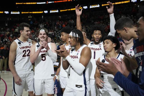 Virginia players celebrate after defeating Illinois in an NCAA college basketball game Sunday, Nov. 20, 2022, in Las Vegas. (AP Photo/John Locher)