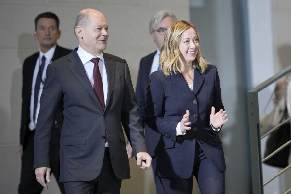 German Chancellor Olaf Scholz, left, and Italian Prime Minister Giorgia Meloni, walk to a family photo with their ministers during a meeting of the German and Italian government at the chancellery in Berlin, Germany, Wednesday, Nov. 22, 2023. (AP Photo/Markus Schreiber)