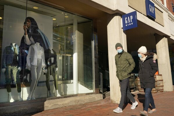 Passers-by walks near an entrance to a Gap clothing store, Thursday, Feb. 25, 2021, in Cambridge, Mass.  Bouncing back from months of retrenchment, America’s consumers stepped up their spending by a solid 2.4% in January in a sign that the economy may be making a tentative recovery from the pandemic recession. Friday’s report from the Commerce Department also showed that personal incomes, which provide the fuel for spending, jumped 10% last month, boosted by cash payments most Americans received from the government. (AP Photo/Steven Senne)