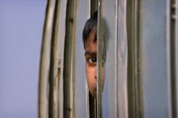 
              In this Jan. 18, 2018, file photo, a relocated Rohingya boy looks out from a bus window as he arrives at the Balukhali refugee camp outside Cox's Bazar, Bangladesh. (AP Photo/Manish Swarup, File)
            