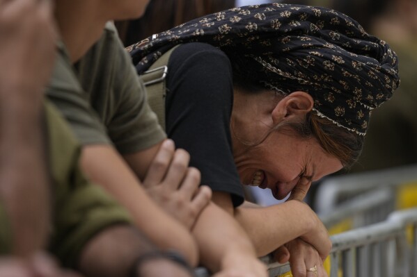 FILE - A woman cries during the funeral of Israeli Col. Roi Levy at the Mount Herzl cemetery in Jerusalem on Monday, Oct. 9, 2023. Col. Levy was killed after Hamas militants stormed from the blockaded Gaza Strip into nearby Israeli towns. (AP Photo/Maya Alleruzzo, File)