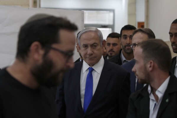 Israeli Prime Minister Benjamin Netanyahu, center, arrives at the District Court in Jerusalem, Israel, Sunday, June 25, 2023. Hollywood producer Arnon Milchan was testifying Sunday at Netanyahu’s corruption trial to answer questions about an alleged “supply line” of champagne and cigars funneled to the Israeli leader and his wife said to have been in exchange for help with Milchan’s personal and business needs. Milchan appeared by videoconference from the English city of Brighton. (Atef Safadi/Pool Photo via AP)