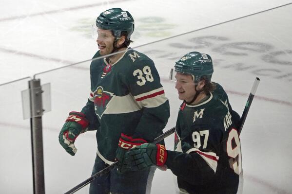 Minnesota Wild's Ryan Hartman (38) celebrates with Kirill Kaprizov (97) after Kaprizov scored his second goal in the first period of the team's NHL hockey game against the Boston Bruins, Wednesday, March 16, 2022, in St. Paul, Minn. (AP Photo/Jim Mone)