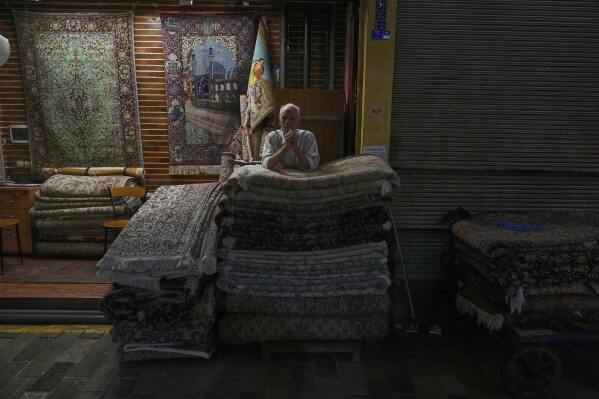 A carpet seller stands at his shop at Tehran's old main bazaar, Iran, Monday, May 5, 2025. (AP Photo/Vahid Salemi)