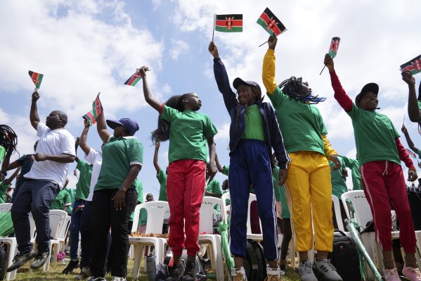 People jump and wave Kenyan flags during the 60th Jamhuri Day Celebrations (Independence Day) at Uhuru gardens Stadium in Nairobi, Monday, Dec. 12, 2023. Thousands of Kenyans braved a chilly morning to attend festivities Tuesday in the capital Nairobi, to mark 60 years since the East African country gained independence from British Colonial rule. (AP Photo/Brian Inganga)