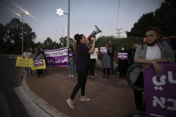 Protesters hold signs and chant slogans during a demonstration against violence near the house of Public Security Minister Omer Barlev in the central Israeli town of Kokhav Ya'ir, Saturday, Sept. 25, 2021. Arab citizens of Israel are seeking to raise awareness about the spiraling rate of violent crime in their communities under the hashtag "Arab lives matter," but unlike a similar campaign in the United States, they are calling for more policing, not less. (AP Photo/Sebastian Scheiner)
