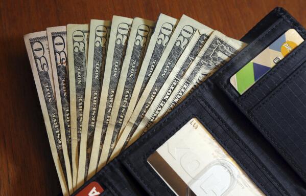 FILE - Cash is fanned out from a wallet in North Andover, Mass., June 15, 2018. The U.S. economy grew faster than expected in the July-September 2022 quarter, the government reported Thursday, Oct. 27, 2022, underscoring that the United States is not in a recession despite distressingly high inflation and interest rate hikes by the Federal Reserve. But the economy is hardly in the clear. (AP Photo/Elise Amendola, File)