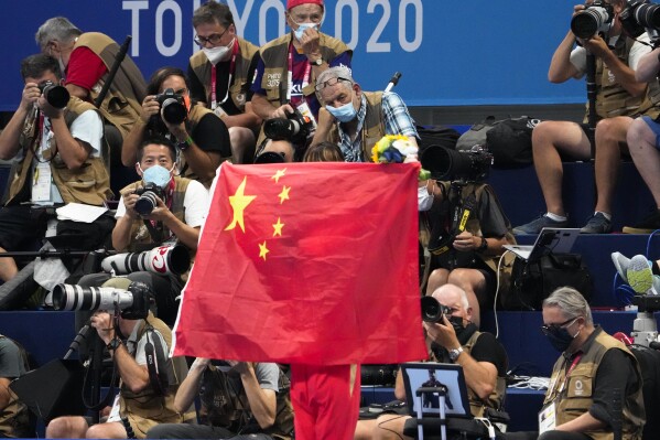 FILE - A Chinese flag is unfurled on the podium of a swimming event final at the 2020 Summer Olympics, on July 29, 2021, in Tokyo, Japan. An Australian newspaper said Saturday, April 20, 2024, 23 Chinese swimmers were cleared to compete at the Tokyo Olympics despite testing positive to doping because world governing bodies agreed with Chinese authorities and ruled that the tests had been contaminated.(Ǻ Photo/Charlie Riedel, File)