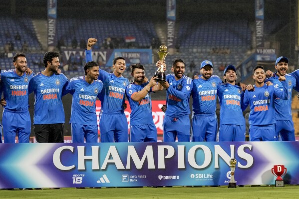 Indian players celebrate as they pose for photograph with trophy after winning the fifth T20 match and series against Australia in Bengaluru, India, Sunday, Dec. 3, 2023. (AP Photo/Aijaz Rahi)