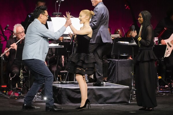 Jon M. Chu, from left, director of the upcoming film "Wicked: For Good," Ariana Grande, and Cynthia Erivo, cast members of the upcoming film "Wicked: For Good," appear onstage during the Universal Pictures and Focus Features presentation at CinemaCon on Wednesday, April 2, 2025, at Caesars Palace in Las Vegas. (AP Photo/Chris Pizzello)