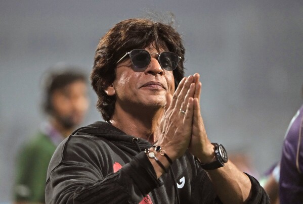 FILE - Bollywood superstar Shah Rukh Khan acknowledges the crowd after his team Kolkata Knight Riders' victory in the Indian Premier League (IPL) cricket match against Royal Challengers Bangalore in Kolkata, India on April 6, 2023.  India's Hindi language film industry, Bollywood, witnessed an impressive financial recovery in 2023 after the pandemic-induced recession, audience fatigue with big studio productions and Bollywood megastars, and streaming platforms snatching away a large share of viewership.  (AP Photo/Vikas Das, File)