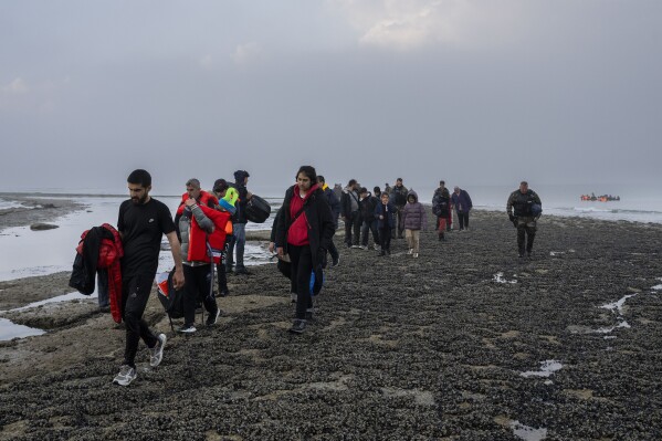 A group of Kurdish migrants from Iran and Iraq who failed in their attempt to reach the United Kingdom by boat after being discovered by the police walk back to the town of Ambleteuse, northern France, on Sunday, May 19, 2024. (AP Photo/Bernat Armangue)