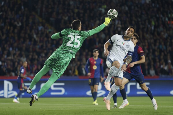Barcelona's goalkeeper Wojciech Szczesny clears the ball in front of Inter Milan's Lautaro Martinez during the Champions League semifinal first leg soccer match between Barcelona and Inter Milan at the Lluis Companys Olympic Stadium in Barcelona, Spain, Wednesday, April 30, 2025. (AP Photo/Joan Monfort)