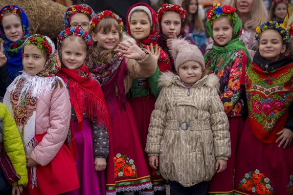 Children wearing traditional outfits wait before performing songs during a show of traditions for Masnytsia, a holiday that originates in pagan times, celebrating the end of winter, in Kyiv, Ukraine, Saturday, March 16, 2024. (AP Photo/Vadim Ghirda)