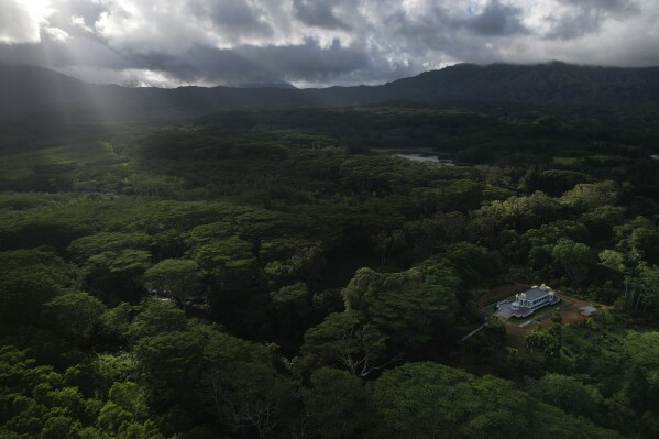 The sun shines down onto the Iraivan Temple surrounded by lush forest at Kauai's Hindu Monastery, on July 10, 2023, in Kapaa, Hawaii. The temple is made entirely of hand-carved granite, which the monks have been constructing for the last 33 years. It was completed in March and marked with a special opening ceremony the same month. (AP Photo/Jessie Wardarski)