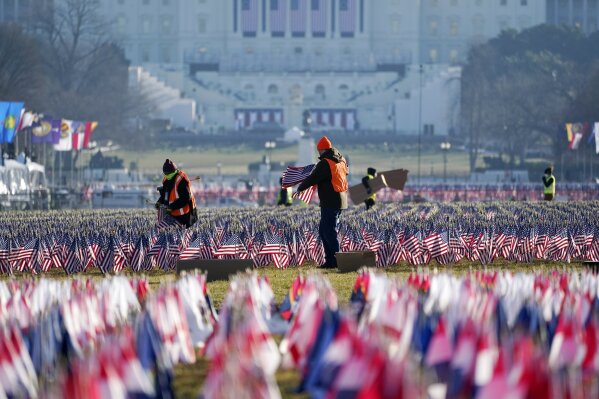 Workers begin to remove a display of flags on the National Mall one day after the inauguration of President Joe Biden, Thursday, Jan. 21, 2021, in Washington. (AP Photo/Julio Cortez)