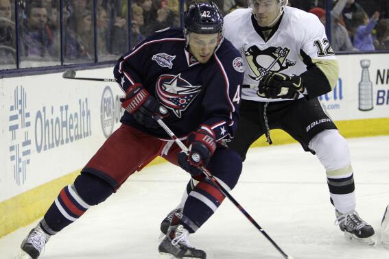 FILE - In this Saturday, April 4, 2015, file photo, Columbus Blue Jackets' Artem Anisimov, left, of Russia, carries the puck behind the net as Pittsburgh Penguins' Ben Lovejoy defends during the second period of an NHL hockey game in Columbus, Ohio. Anisimov is part of a seven-player trade that sends him to the Chicago Blackhawks. (AP Photo/Jay LaPrete, File)