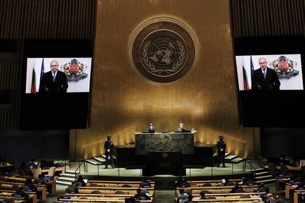 Bulgaria's President Rumen Radev is seen on video screens as he addresses the 76th Session of the United Nations General Assembly remotely, Tuesday, Sept. 21, 2021 at U.N. headquarters. (Spencer Platt/Pool Photo via AP)