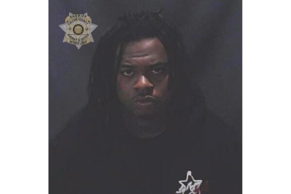 This image provided by the Fulton County Sheriff's Office shows rapper Gunna, whose given name is Sergio Kitchens. Rapper Gunna was booked into a jail in Atlanta Wednesday, May 11, 2022 on a racketeering charge after he was indicted with fellow rapper Young Thug and more than two dozen other people. An indictment filed Monday in Fulton County Superior Court accuses him of violating Georgia's anti-racketeering law. It was not immediately clear whether he had a lawyer who could comment on the charges. (Fulton County Sheriff's Office via AP)