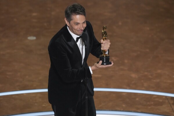 Sean Baker accepts the award for best original screenplay for "Anora" during the Oscars on Sunday, March 2, 2025, at the Dolby Theatre in Los Angeles. (AP Photo/Chris Pizzello)
