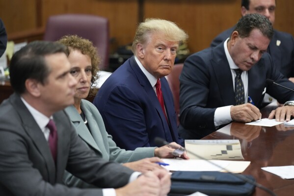 FILE - Former President Donald Trump sits at the defense table with his legal team in a Manhattan court, April 4, 2023, in New York. A federal judge has rejected Donald Trump’s bid to move his hush-money criminal case from New York state court to federal court. He ruled that the former president had failed to meet a high legal bar for changing jurisdiction. (AP Photo/Seth Wenig, Pool, File)