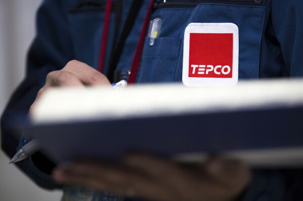 FILE - A Tokyo Electric Power Co. (TEPCO) logo is seen on a uniform of an employee at the company's Fukushima Dai-ichi nuclear power plant in Okuma town, Fukushima prefecture, Japan, on Feb. 23, 2017. A Tokyo court on Tuesday, Dec. 26, 2023 ruled that only the Tokyo Electric Power Company Holdings, known as TEPCO, the operator of the tsunami-wrecked Fukushima nuclear power plant had to pay damages to dozens of evacuees, relieving the government of responsibility. Plaintiffs criticized the ruling as belittling their suffering and the severity of the disaster.(Tomohiro Ohsumi/Pool Photo via AP, File)