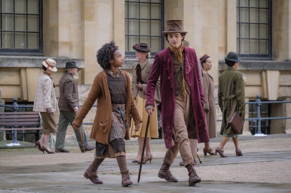 This image released by Warner Bros. Pictures shows Calah Lane, left, and Timothee Chalamet in a scene from "Wonka." (Warner Bros. Pictures via AP)