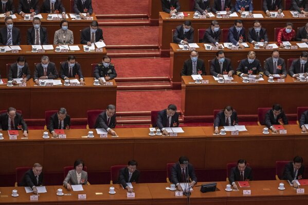 Chinese President Xi Jinping, top center, and Premier Li Keqiang, top right, with other delegates vote during the closing session of the National People's Congress (NPC), at the Great Hall of the People, in Beijing, Thursday, March 11, 2021. China’s ceremonial legislature has endorsed the ruling Communist Party’s latest move to tighten control over Hong Kong by reducing the role of its public in picking the territory’s leaders. (Roman Pilipey/Pool Photo via AP)