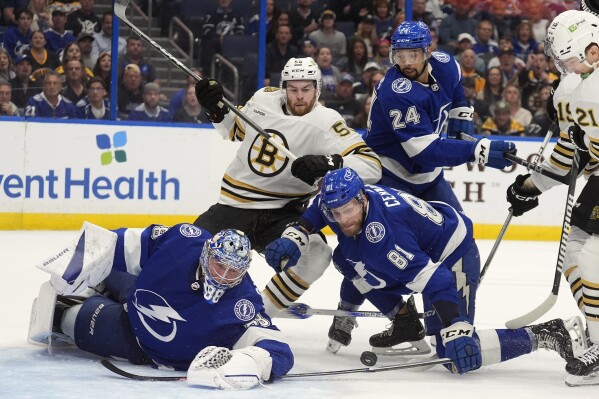Boston Bruins right wing Justin Brazeau (55) and Tampa Bay Lightning defenseman Erik Cernak (81) battle for a loose puck in front of goaltender Andrei Vasilevskiy (88) during the first period of an NHL hockey game Wednesday, March 27, 2024, in Tampa, Fla. (AP Photo/Chris O'Meara)