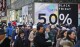 File - Crowds walk past a large store sign displaying a Black Friday discount in midtown Manhattan, Friday, Nov. 23, 2018, in New York. While Black Friday may no longer look like the crowd-filled, in-person mayhem that it was just decades ago — in large part due to the rising dependence on online shopping that was accelerated by the COVID-19 pandemic — the holiday sales event is still slated to attract millions of consumers. (AP Photo/Bebeto Matthews, File)