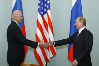 FILE - In this March 10, 2011, file photo, Vice President of the United States Joe Biden, left, shakes hands with Russian Prime Minister Vladimir Putin in Moscow, Russia. Russian President Vladimir Putin has congratulated Joe Biden on winning the U.S. presidential election after weeks of holding out. Putin's message to Biden on Tuesday, Dec. 15, 2020, came a day after the Electoral College confirmed Biden as the nation's next president. The Russian president is one of the last world leaders to congratulate Biden. (AP Photo/Alexander Zemlianichenko, File)