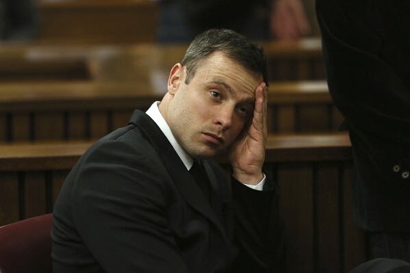 FILE - Oscar Pistorius gestures, at the end of the fourth day of sentencing proceedings in the high court in Pretoria, South Africa, Thursday, Oct. 16, 2014. Pistorius will have a second chance at parole at a hearing on Friday, Nov. 24, 2023 after he was wrongly ruled ineligible for early release from jail in March. South Africa’s department of corrections said in a statement on Monday, Nov. 20 that a parole board will consider the former Olympic runner’s case again this week. Pistorius turns 37 on Wednesday and has been in prison for nearly a decade. (Alon Skuy/Pool Photo via AP, File)