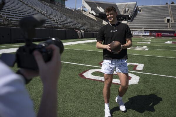 FILE - Adam Botkin a football TikTok influencer, records a video for a post at Washington-Grizzly Stadium in Missoula, Mont., on May 1, 2023. Botkin, a former walk-on place kicker and punter for the Montana Grizzlies, gained notoriety on the social media platform after videos of him performing kicking tricks went viral. TikTok, Inc., filed a lawsuit Monday, May 22, 2023, seeking to overturn Montana's first-in-the-nation ban on the video sharing app, arguing the law is an unconstitutional violation of free speech rights and is based on “unfounded speculation” that the Chinese government could access users' data. (AP Photo/Tommy Martino, File)