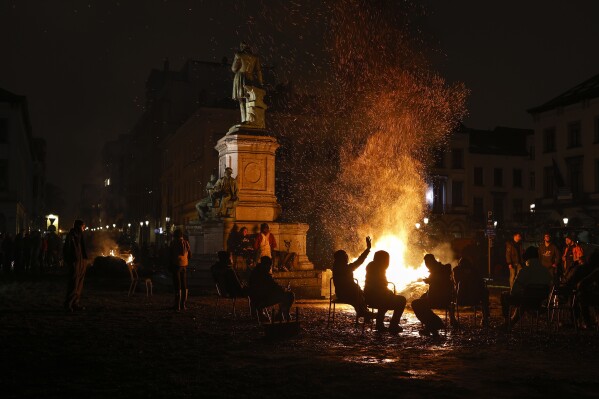 FILE - Farmers warm themselves around a fire as they gather in a protest in front of the European Parliament ahead of the EU summit in Brussels, Thursday, February 1, 2024.  (AP Photo/Omar Habana, File)