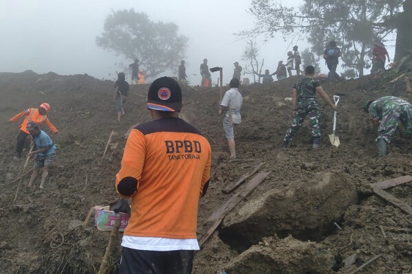 In this photo released by Tana Toraja Regional Disaster Management Agency (BPBD Tana Toraja), rescuers search for victims of a landslide in Tana Toraja, South Sulawesi, Indonesia, Monday, April 15, 2024. Loosened by torrential rain, mud poured from surrounding hills onto houses just before midnight on Saturday killing a number of people, officials said. (BPBD Tana Toraja via AP)