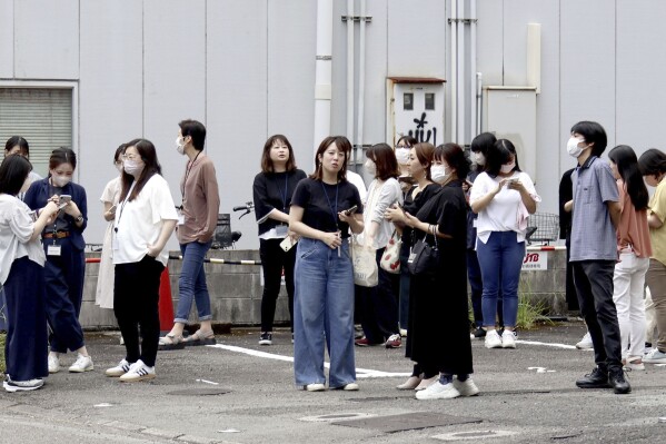 People take shelter outside building following an earthquake in Miyazaki, western Japan, Thursday, Aug. 8, 2024.(Kyodo News via AP)