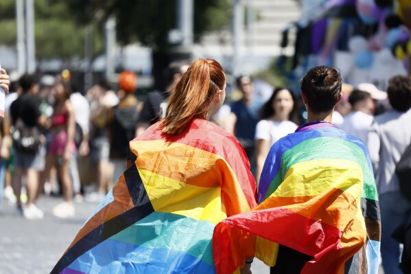 People wrapped in rainbow flags take part in the LGBTQ+ Pride parade in Rome, Saturday, June 10, 2023. (Cecilia Fabiano/LaPresse via AP, File)