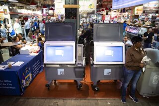 In this Thursday, June 13, 2019 photo, ExpressVote XL voting machines are displayed during a demonstration at the Reading Terminal Market in Philadelphia. The machines are made by Election Systems & Software, one of three voting-machine companies that disclosed to North Carolina election officials the substantial ownership stakes held by private equity firms  (AP Photo/Matt Rourke)