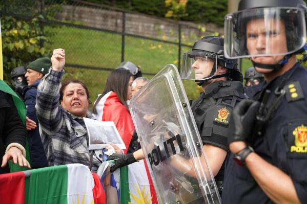 Policemen stand guard as demonstrators gather outside Iran's embassy in Oslo, Norway, Thursday, Sept. 29, 2022, to protest the death of 22-year-old Mahsa Amini in custody in Iran after she was detained by the country’s morality police. Several people attempted to enter the Iranian Embassy in Oslo, police said Thursday, with scuffles breaking out and rocks being thrown at officers with authorities saying some 90 people had been detained. (Terje Pedersen/NTB Scanpix via AP)