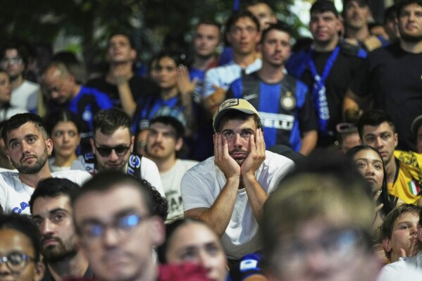 Inter Milan fans react as they watch their team play PSG in the Champions League final soccer match in open pub in Milan, Italy, Saturday, May 31, 2025. (AP Photo/Antonio Calanni)