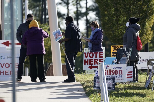 FILE - Voters are assisted at a polling location at the South Regional Library in Durham, N.C., Nov. 3, 2020. In North Carolina and Wisconsin, Republicans are trying to seize power over elections and redistricting. Both states are evenly divided political battlegrounds where the GOP controls an outsized number of seats in the state legislature. In Wisconsin, that's largely due to a gerrymander that locks in a GOP majority. (AP Photo/Gerry Broome, File)