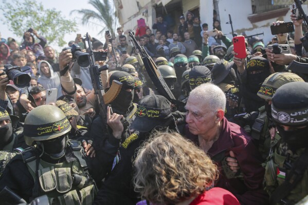 gadi moses, 80, center right, who has been held hostage by hamas in gaza since october 7, 2023, is escorted by hamas and islamic jihad fighters as he is handed over to the red cross in khan younis, southern gaza strip, thursday, jan. 30, 2025. (ap photo/jehad alshrafi)